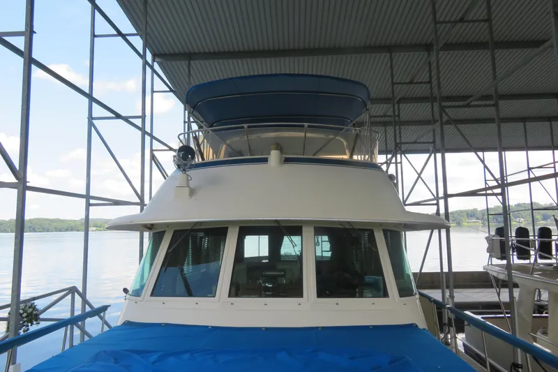 Rive' Gauche Yacht Photos Pics 1986 Hatteras 58 Motor Yacht docked under a covered marina with scenic lake view.