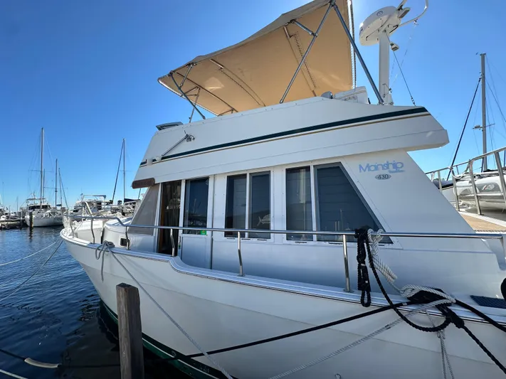 Northstar Yacht Photos Pics 2002 Mainship 430 Trawler docked at marina under clear blue sky.