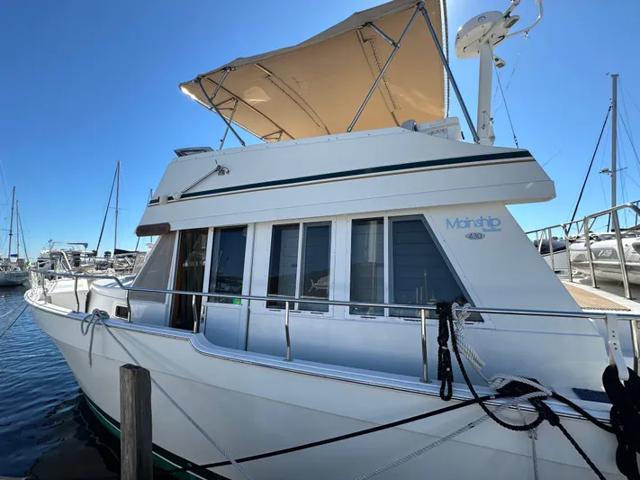 Northstar Yacht Photos Pics 2002 Mainship 430 Trawler docked, featuring a beige canopy and sleek design.