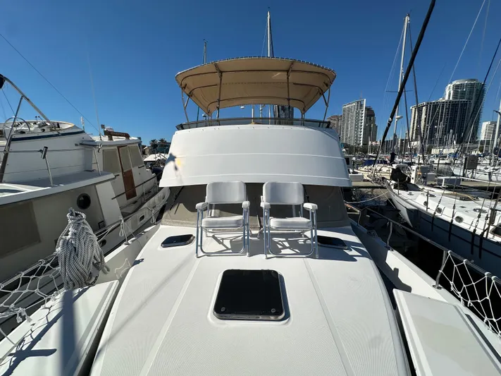 Northstar Yacht Photos Pics 2002 Mainship 430 Trawler docked, featuring spacious deck and seating under clear blue sky.