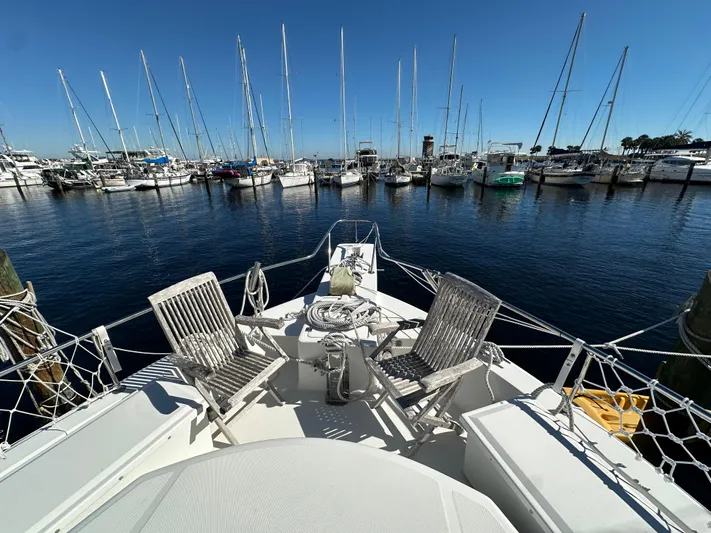 Northstar Yacht Photos Pics 2002 Mainship 430 Trawler at marina, featuring deck chairs and nautical equipment.