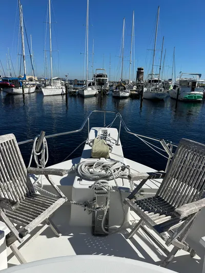 Northstar Yacht Photos Pics 2002 Mainship 430 Trawler docked, featuring deck chairs and nautical ropes, in a marina setting.