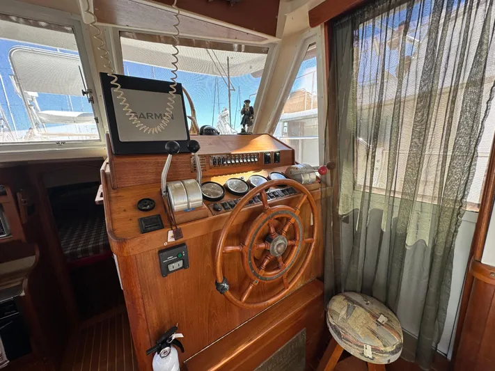 Northstar Yacht Photos Pics 2002 Mainship 430 Trawler helm with wooden wheel, gauges, and nautical decor.