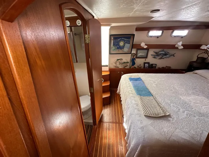 Northstar Yacht Photos Pics Cozy bedroom in 2002 Mainship 430 Trawler with wooden decor and nautical-themed artwork.