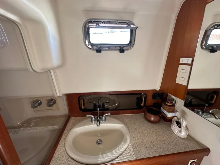 Northstar Yacht Photos Pics 2002 Mainship 430 Trawler bathroom with sink, countertop, and porthole window.
