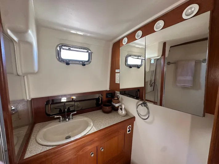 Northstar Yacht Photos Pics Bathroom interior of 2002 Mainship 430 Trawler with sink, mirror, and porthole window.