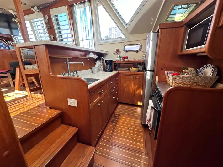 Northstar Yacht Photos Pics 2002 Mainship 430 Trawler kitchen with wooden cabinetry, stainless steel appliances, and ample natural light.