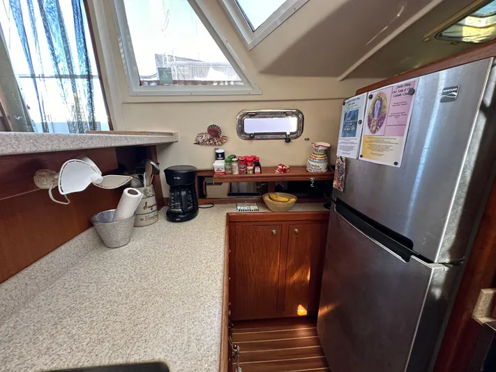 Northstar Yacht Photos Pics 2002 Mainship 430 Trawler kitchen with countertop, coffee maker, and stainless steel refrigerator.