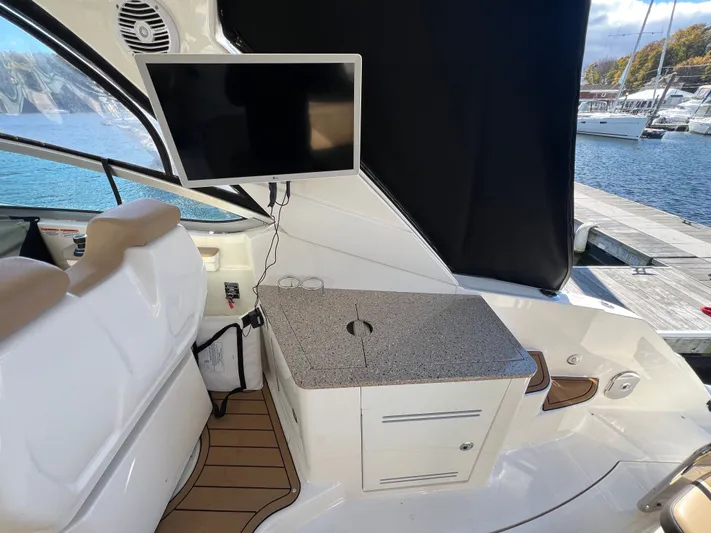  Yacht Photos Pics 2018 Sea Ray 350 Sundancer interior with TV, seating, and countertop by the water.
