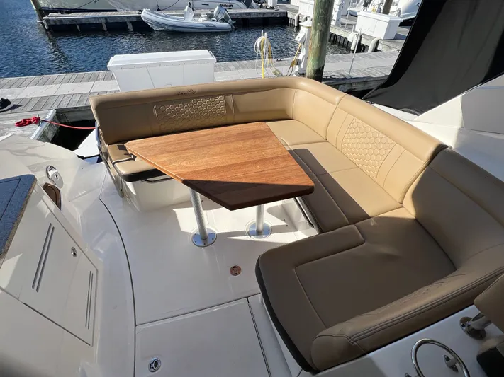  Yacht Photos Pics 2018 Sea Ray 350 Sundancer boat with tan seating and wooden table on deck.
