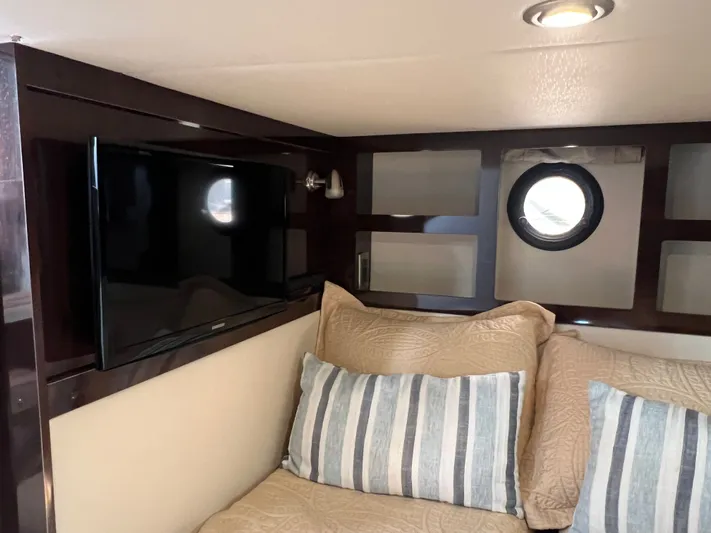  Yacht Photos Pics Interior of 2018 Sea Ray 350 Sundancer with TV, porthole, and cozy bedding.