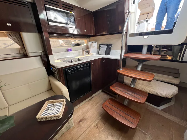  Yacht Photos Pics Interior of 2018 Sea Ray 350 Sundancer yacht with kitchenette, seating, and wooden stairs.