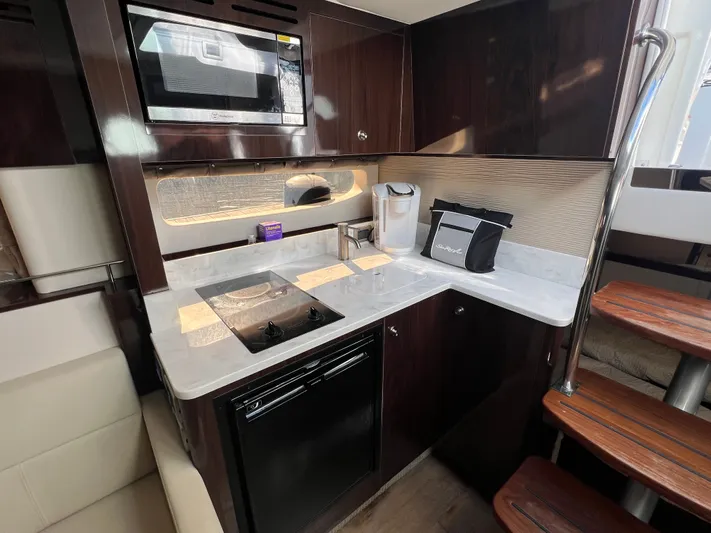  Yacht Photos Pics 2018 Sea Ray 350 Sundancer kitchen with microwave, stove, and modern cabinetry.