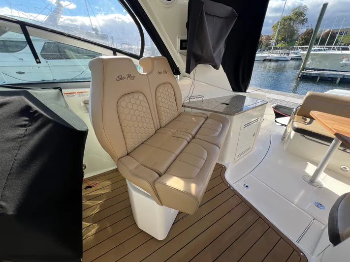  Yacht Photos Pics 2018 Sea Ray 350 Sundancer interior with beige seating and wooden flooring at a marina.