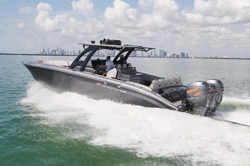  Yacht Photos Pics 2023 Midnight Express 37' Open boat cruising on water with city skyline in background.