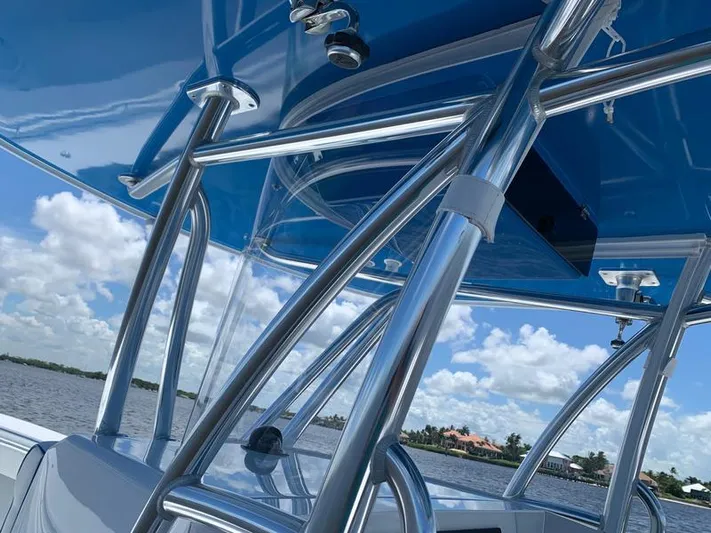  Yacht Photos Pics 2021 Contender 35 ST boat with sleek metal framework and blue canopy on a sunny day.