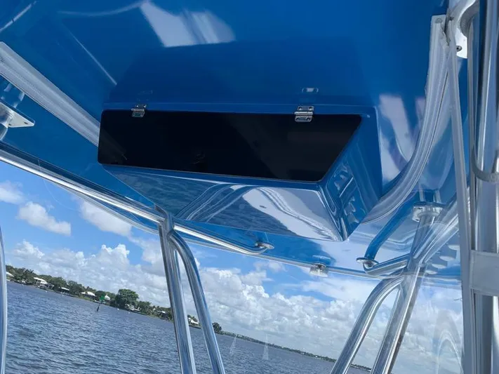  Yacht Photos Pics 2021 Contender 35 ST boat with blue interior and storage compartment, overlooking a scenic water view.