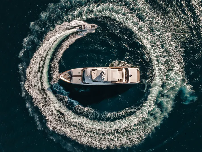 Moatize Yacht Photos Pics Aerial view of 1998 Pendennis Custom yacht with speedboat creating circular wake.