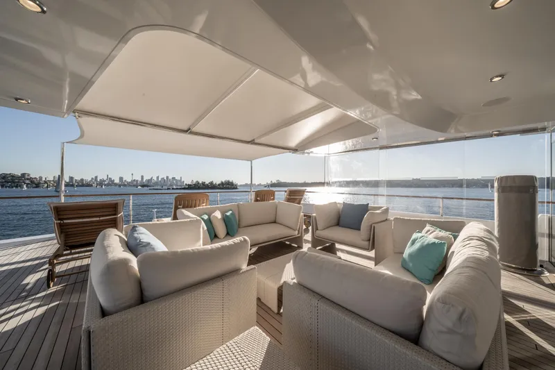 Moatize Yacht Photos Pics Luxurious Pendennis Custom yacht deck with elegant seating, ocean view, and city skyline in the background.