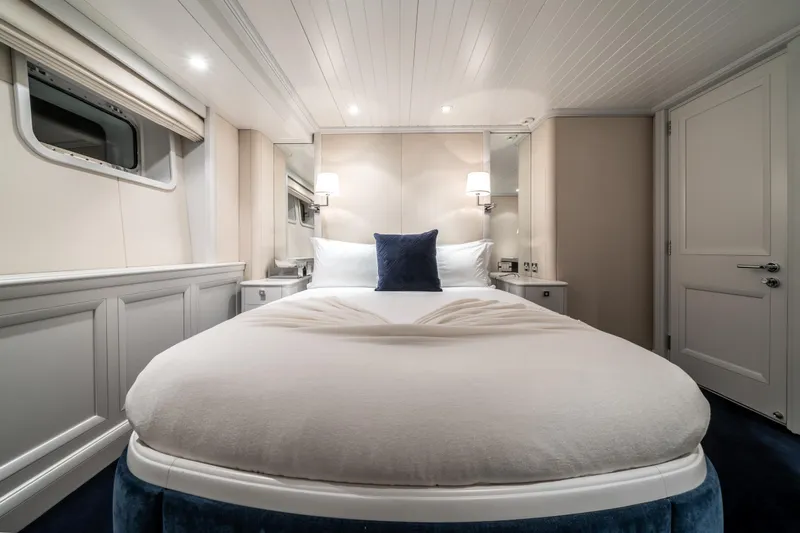 Moatize Yacht Photos Pics Luxurious bedroom interior on 1998 Pendennis Custom yacht, featuring elegant bedding and ambient lighting.