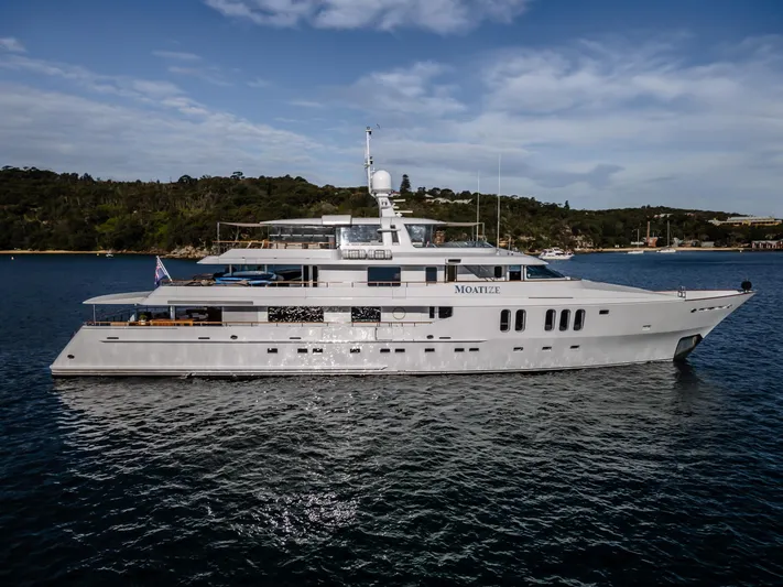 Moatize Yacht Photos Pics Luxurious 1998 Pendennis Custom yacht on serene water with scenic background.