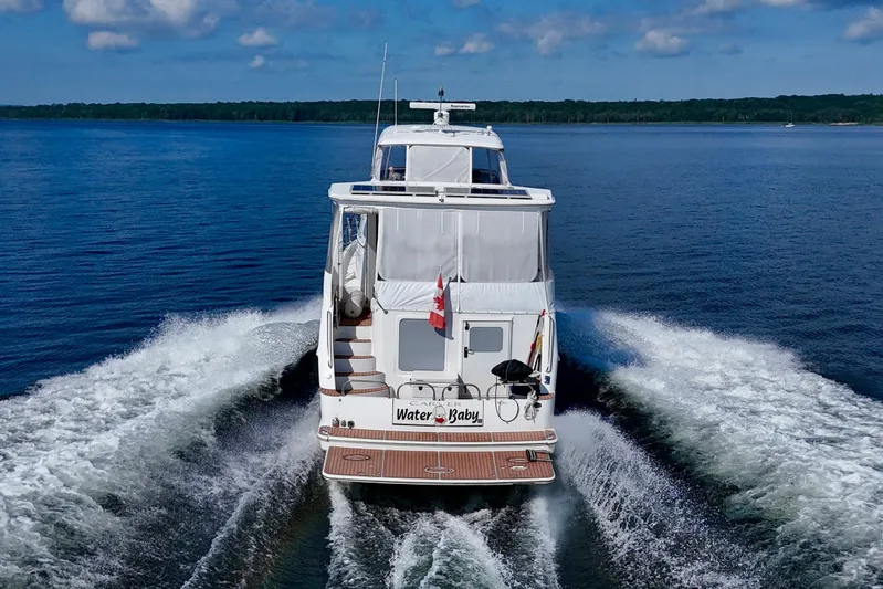 Water Baby Yacht Photos Pics 2007 Carver 43 Motor Yacht cruising on a serene lake under a blue sky.