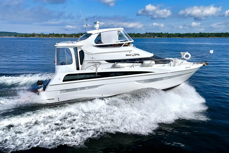 Water Baby Yacht Photos Pics 2007 Carver 43 Motor Yacht cruising on open water under a clear blue sky.