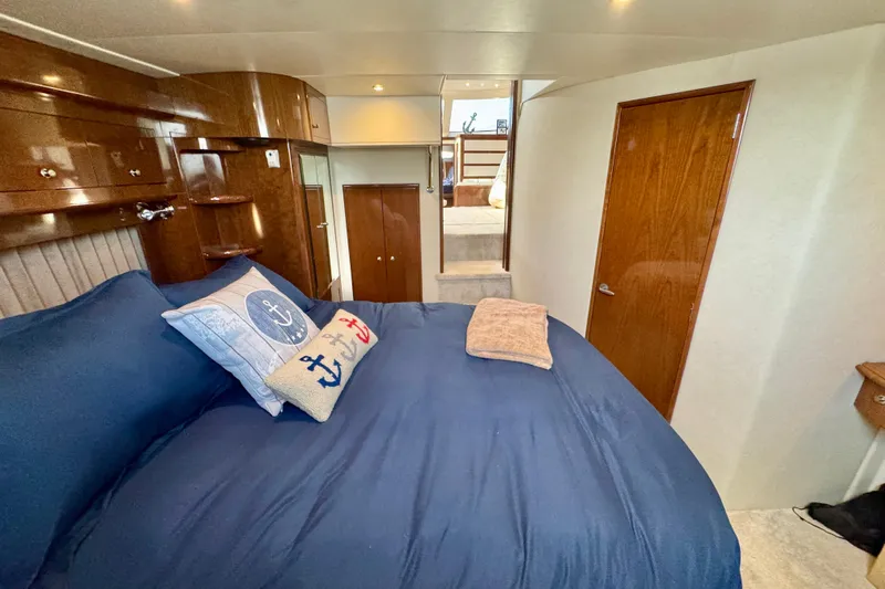 Water Baby Yacht Photos Pics Luxurious 2007 Carver 43 Motor Yacht bedroom with nautical-themed decor and wooden cabinetry.
