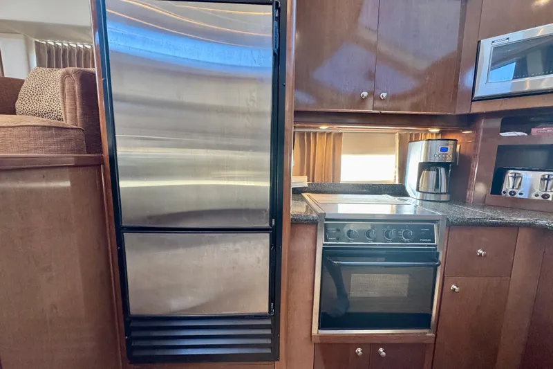 Water Baby Yacht Photos Pics 2007 Carver 43 Motor Yacht kitchen with stainless steel appliances and wooden cabinetry.