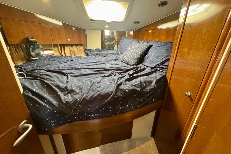 Water Baby Yacht Photos Pics Cozy bedroom in 2007 Carver 43 Motor Yacht with starry bedding and wooden cabinets.
