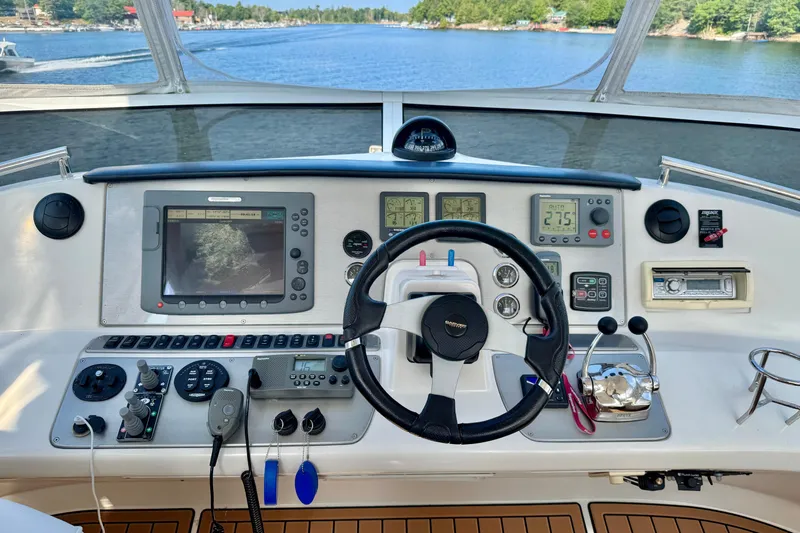 Water Baby Yacht Photos Pics 2007 Carver 43 Motor Yacht helm with navigation equipment and scenic waterway view.