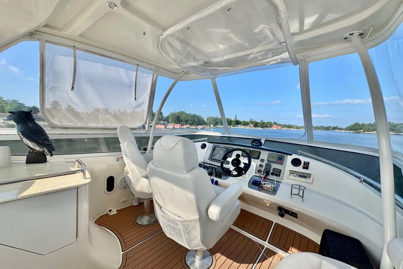 Water Baby Yacht Photos Pics 2007 Carver 43 Motor Yacht helm with panoramic water view, featuring modern controls and seating.