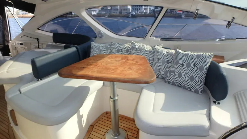 My Way Yacht Photos Pics Luxurious seating area on 2006 Azimut Atlantis 55 yacht with elegant cushions and wooden table.
