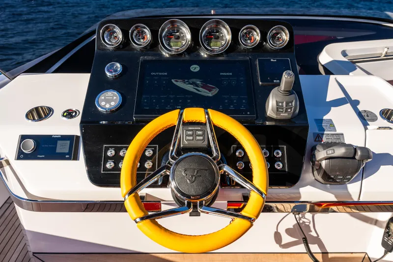  Yacht Photos Pics 2024 Frauscher 1414 Demon yacht dashboard with yellow steering wheel and advanced controls.