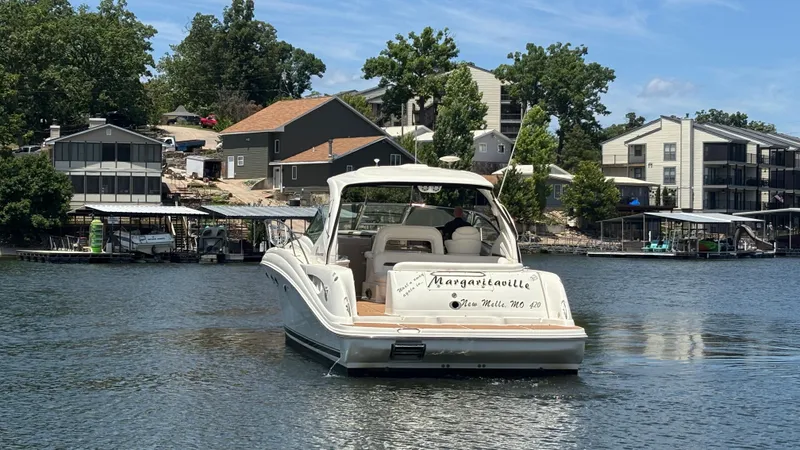  Yacht Photos Pics 2004 Sea Ray 420 Sundancer boat on a lake near waterfront homes.