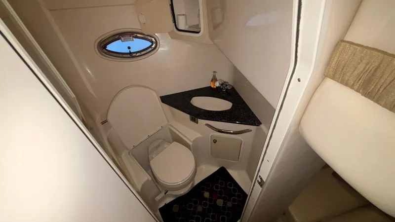  Yacht Photos Pics 2004 Sea Ray 420 Sundancer bathroom with toilet, sink, and porthole window.