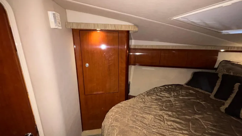  Yacht Photos Pics 2004 Sea Ray 420 Sundancer cabin interior with wood paneling and cozy bedding.