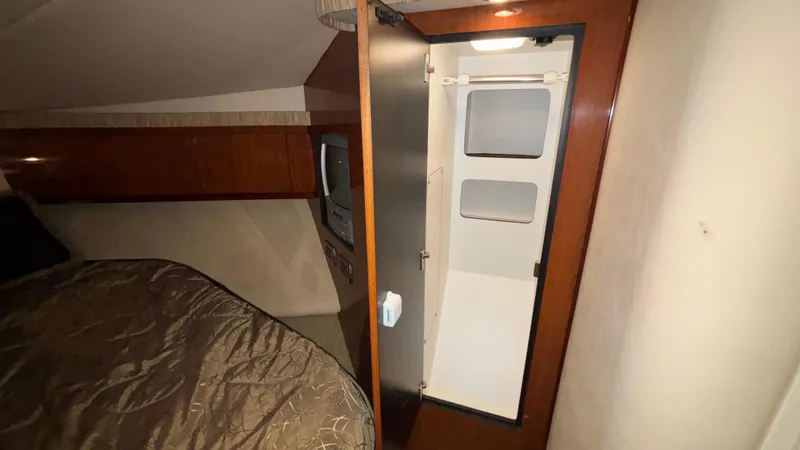  Yacht Photos Pics 2004 Sea Ray 420 Sundancer cabin interior with bed, storage, and open closet.