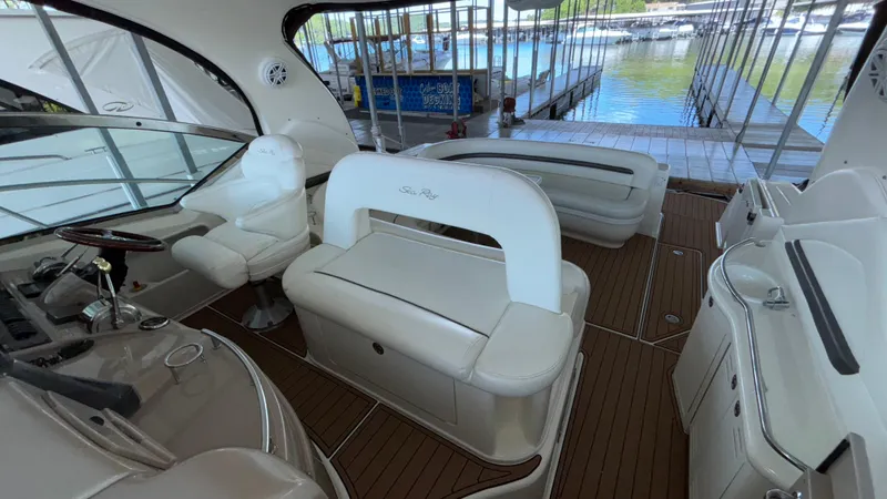  Yacht Photos Pics 2004 Sea Ray 420 Sundancer interior with white seating and wooden flooring at a marina.