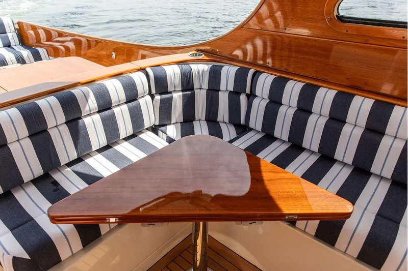 Admiralty Yacht Photos Pics Interior of 2005 Hinckley Picnic Boat EP with striped seating and wooden table.