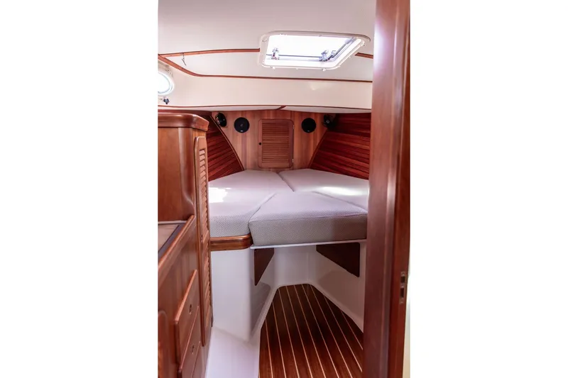 Admiralty Yacht Photos Pics 2005 Hinckley Picnic Boat EP cabin interior with wooden finish and cozy bedding.