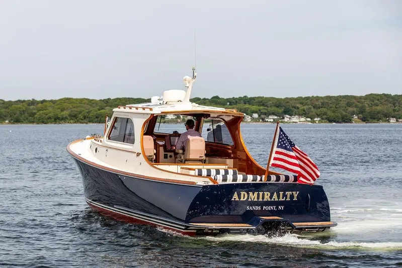 Admiralty Yacht Photos Pics 2005 Hinckley Picnic Boat EP cruising on water with American flag.