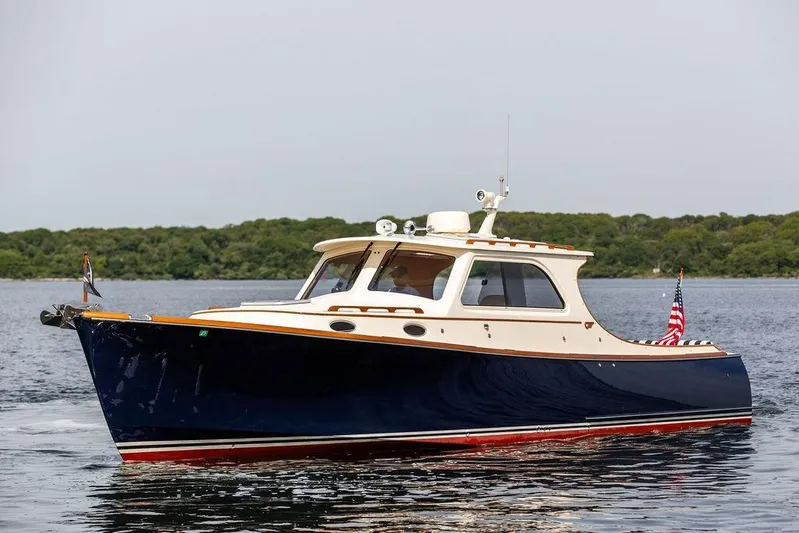 Admiralty Yacht Photos Pics 2005 Hinckley Picnic Boat EP cruising on calm waters with lush greenery in the background.