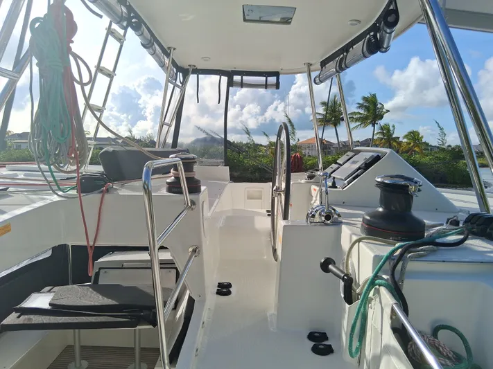 Paper Doll Yacht Photos Pics 2019 Lagoon 450 F catamaran cockpit with steering wheel, ropes, and tropical backdrop.