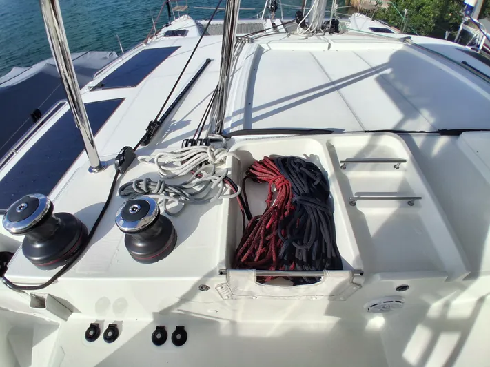 Paper Doll Yacht Photos Pics Deck of 2019 Lagoon 450 F catamaran with ropes and winches, docked by the water.