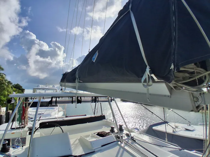 Paper Doll Yacht Photos Pics Lagoon 450 F catamaran, 2019 model, docked with sails covered, under a partly cloudy sky.