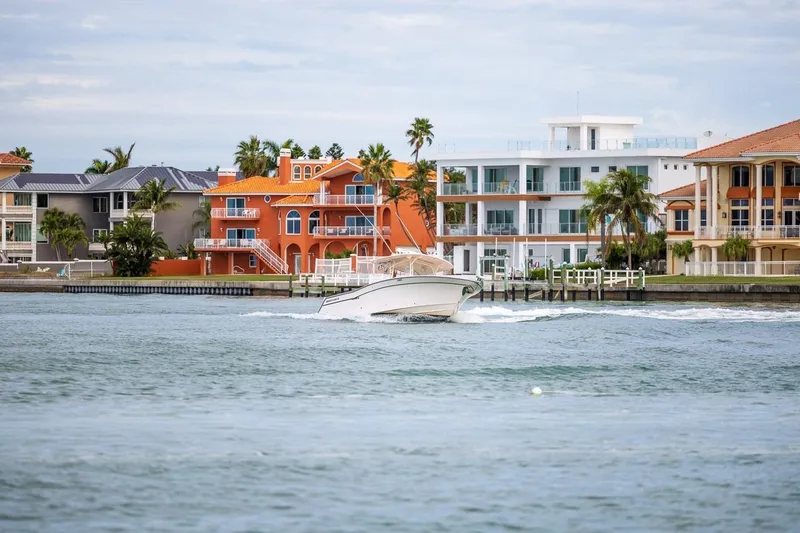  Yacht Photos Pics 2014 Grady-White Canyon 336 boat cruising near colorful waterfront homes.