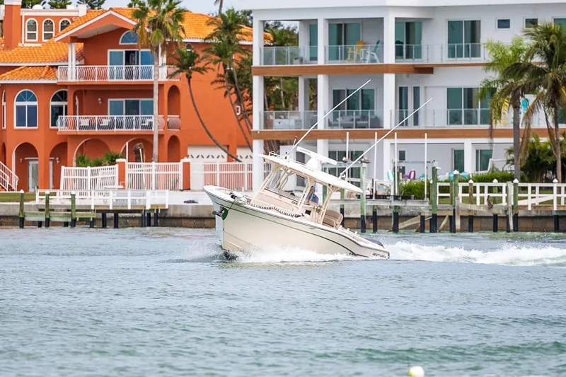  Yacht Photos Pics 2014 Grady-White Canyon 336 boat cruising near waterfront homes.