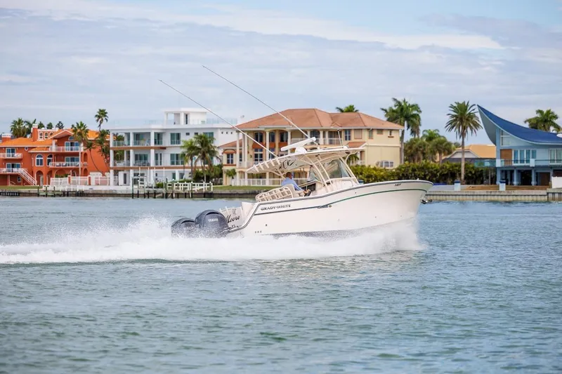  Yacht Photos Pics 2014 Grady-White Canyon 336 boat cruising near colorful waterfront homes.