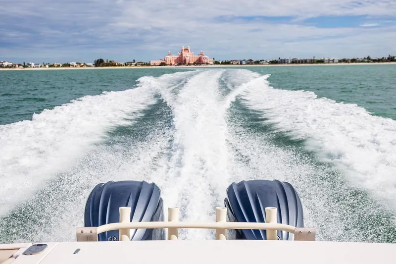  Yacht Photos Pics 2014 Grady-White Canyon 336 boat cruising, leaving wake, with distant shoreline view.